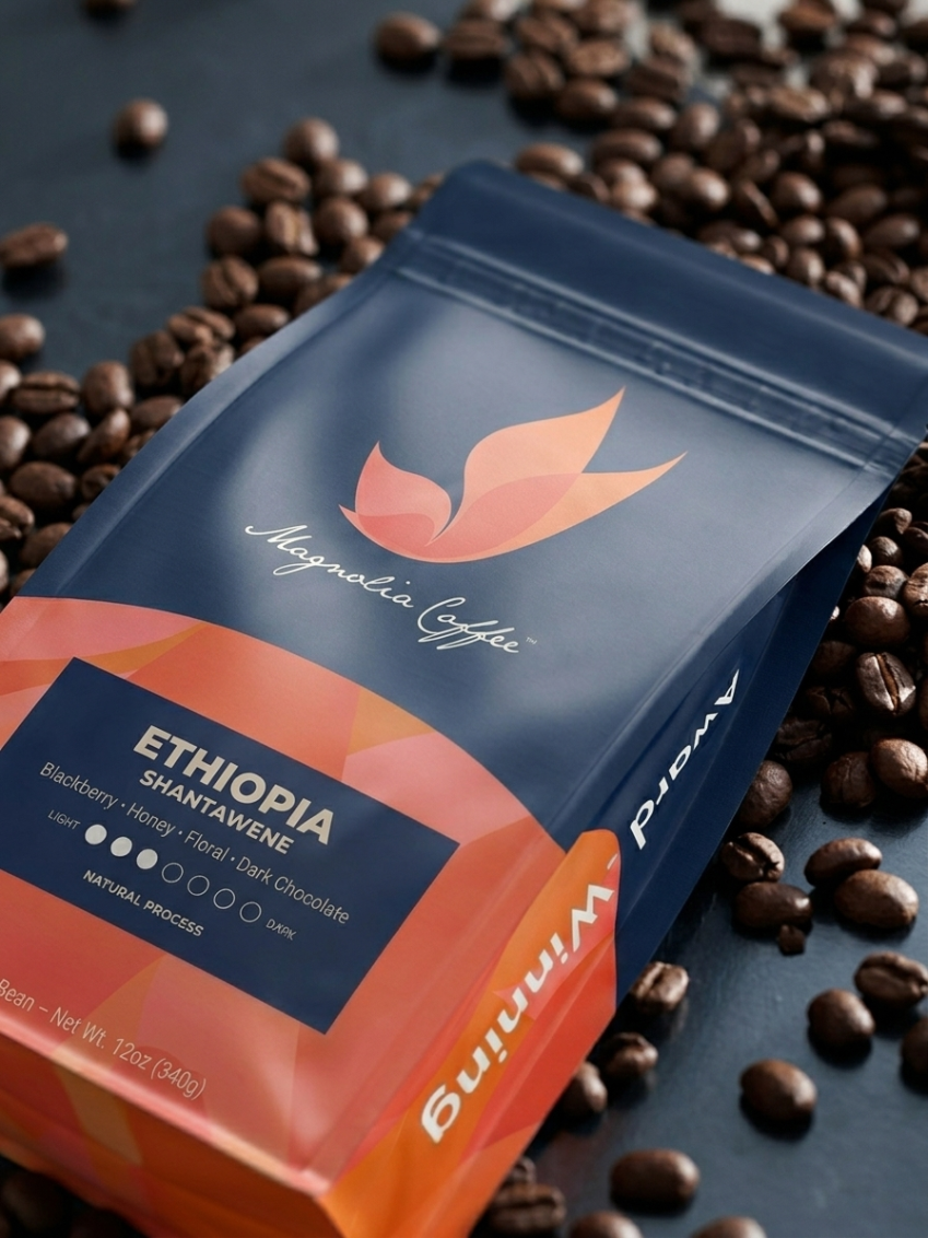 Magnolia Coffee package with coffee beans on a dark surface